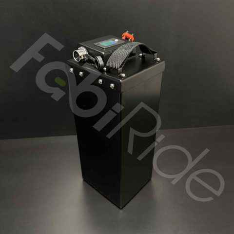 Aukštas juodas „FabiRide“ akumuliatorius su nešiojimo rankena ir LCD ekranu viršuje, pilkame fone.